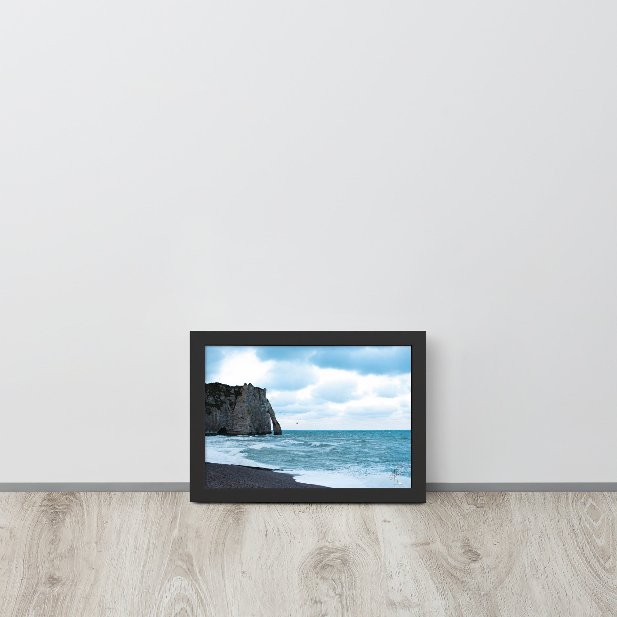 Photographie apaisante de la plage d'Etretat, où la mer caresse le rivage sous un ciel clair. Une représentation parfaite de la tranquillité et de la beauté naturelle de la côte normande.