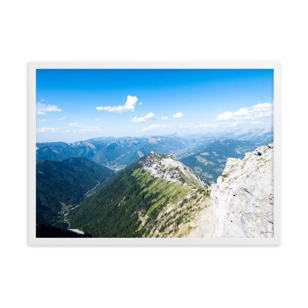 Photographie panoramique des Alpes avec montagnes robustes, vallées verdoyantes, nuages flottants et ciel bleu azur.