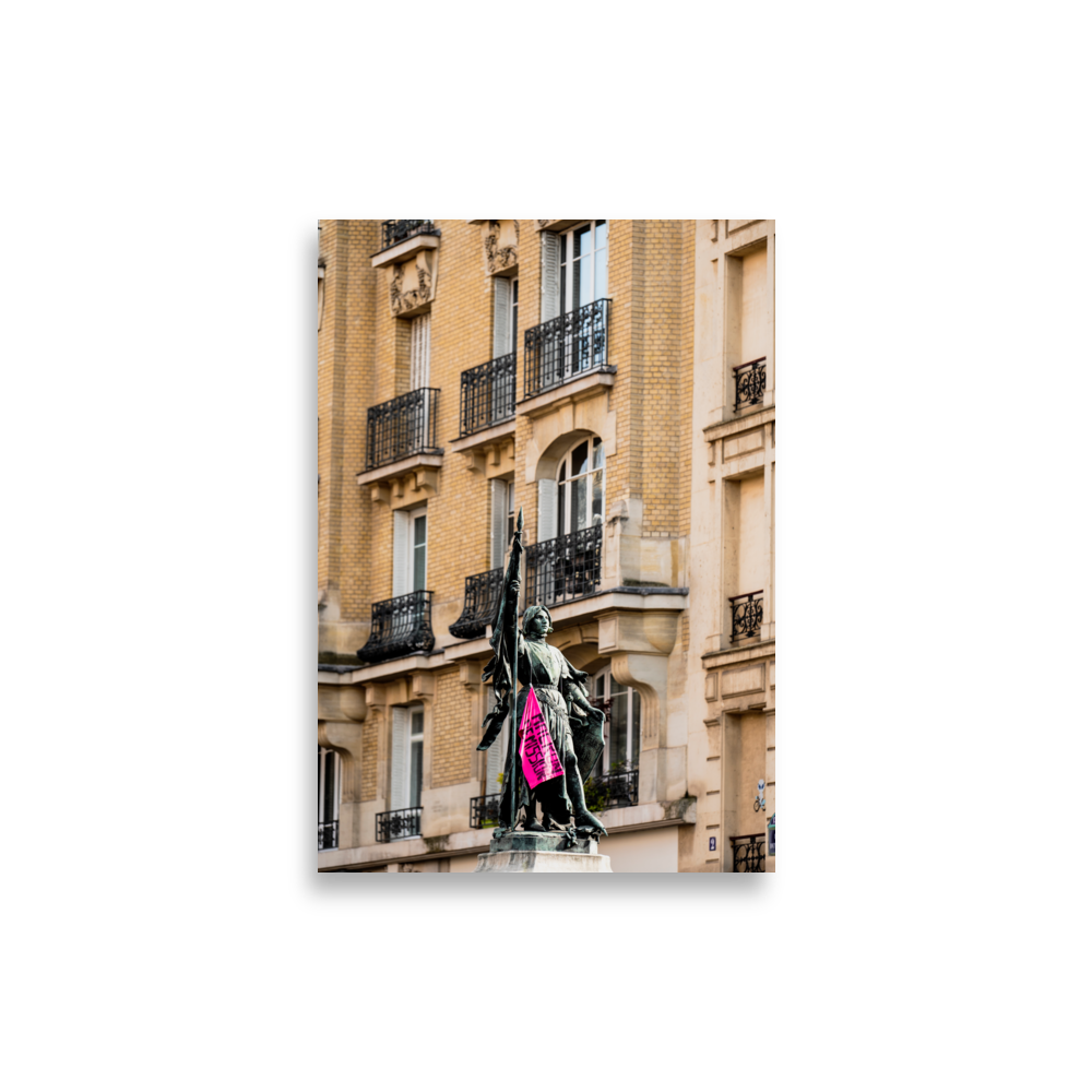 Poster de photographie d'une statue de Jeanne d'Arc ornée d'un drapeau rose de protestation.