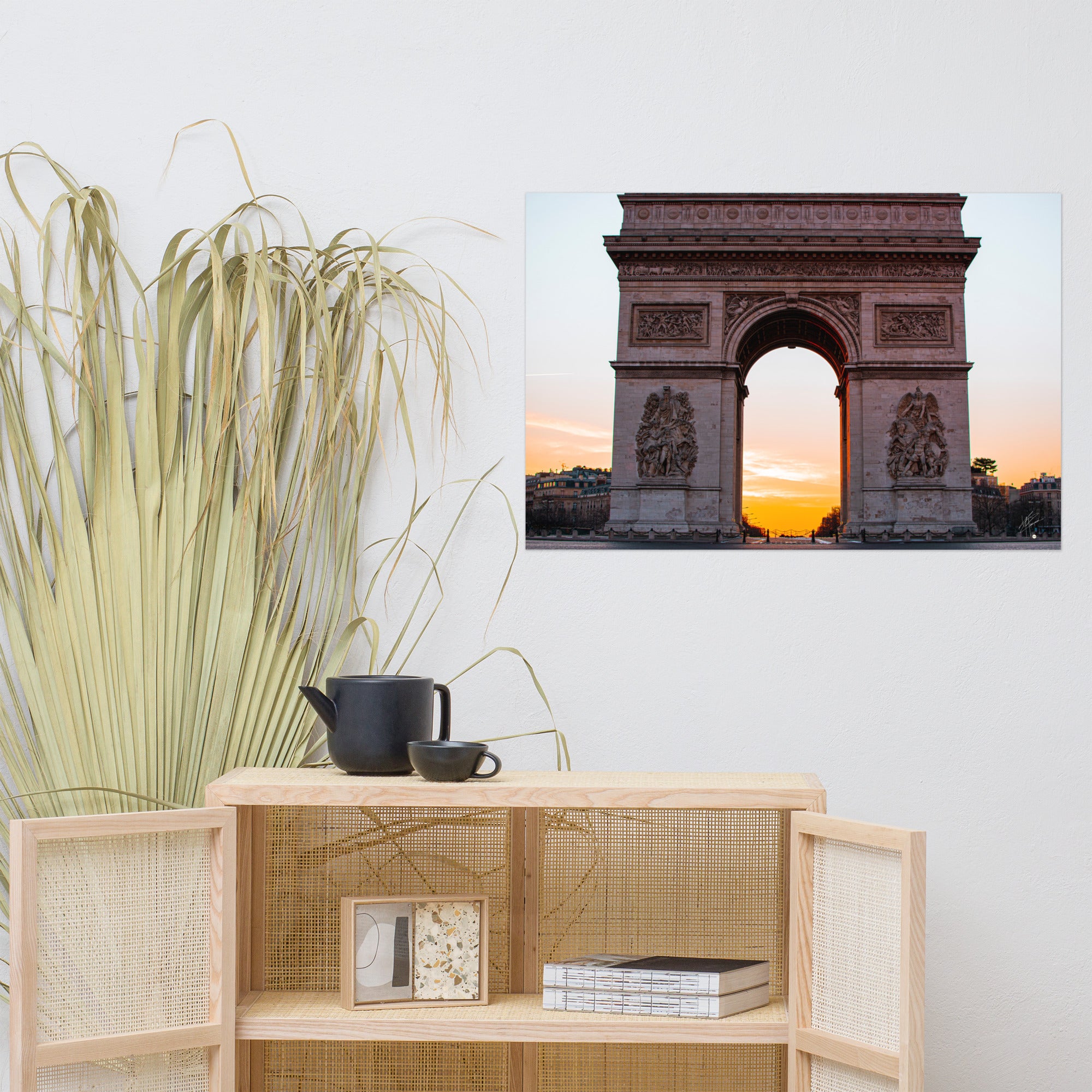 L'Arc de Triomphe de Paris au lever du soleil, ses contours majestueux se découpant contre un ciel orangé, symbolisant la gloire et l'espoir d'une nouvelle journée.